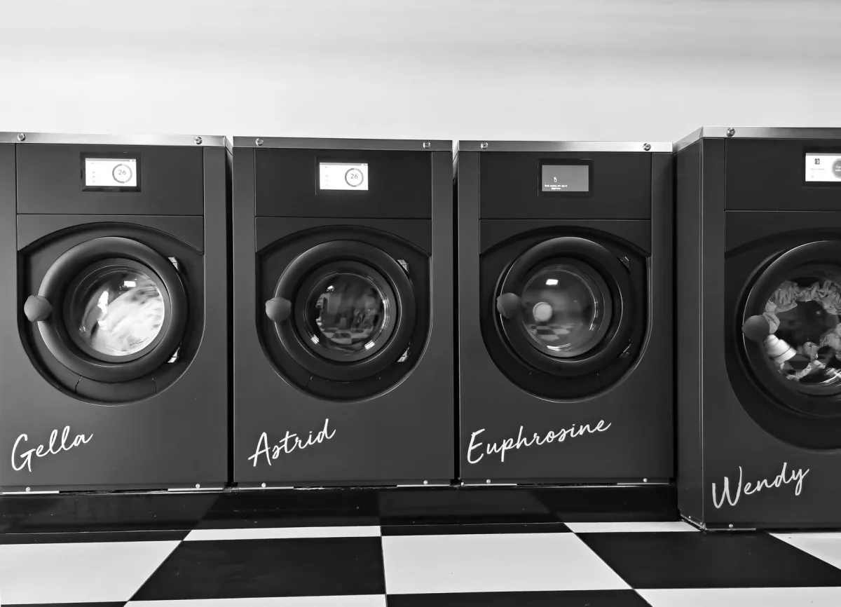 Person loading a front-load washing machine with one load of laundry