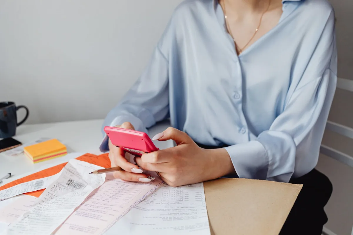 Homeowner using a calculator to plan a monthly maintenance budget