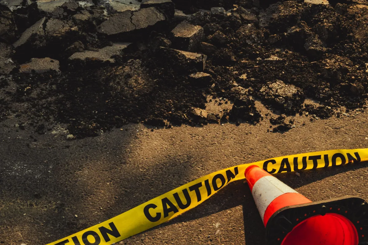 Homeowner digging to uncover a buried concrete septic tank lid