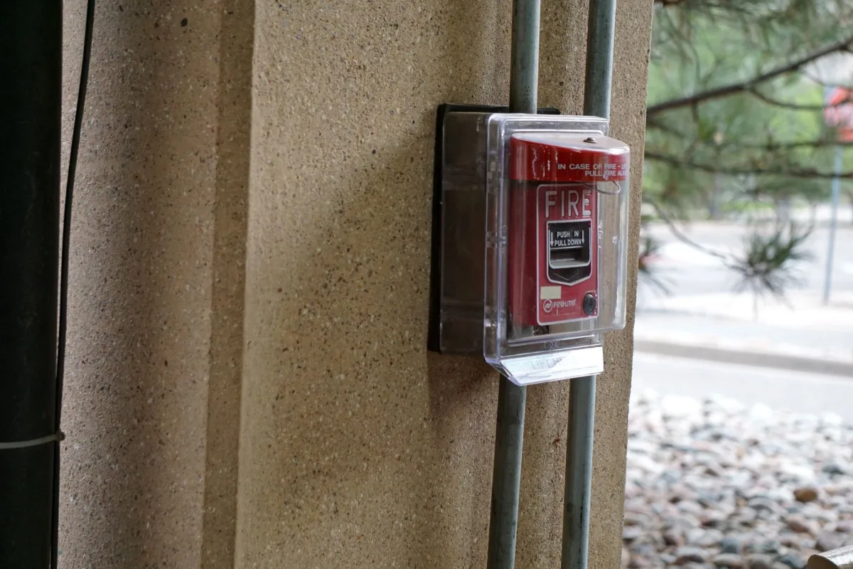 Weatherproof septic alarm box with buzzer and red light near a septic tank