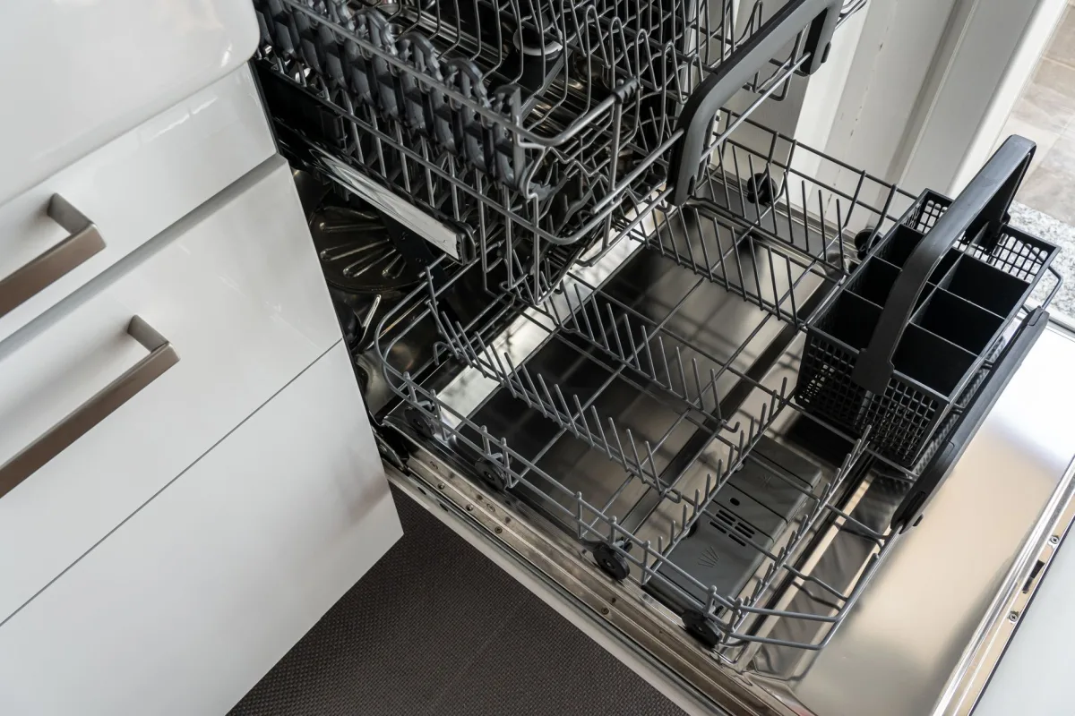 Person loading plates into a dishwasher rack in a septic home kitchen