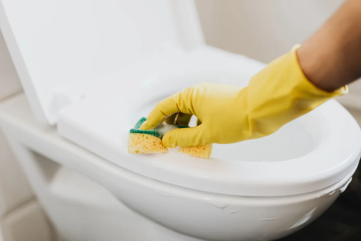 Hand adjusting the flapper inside a toilet tank