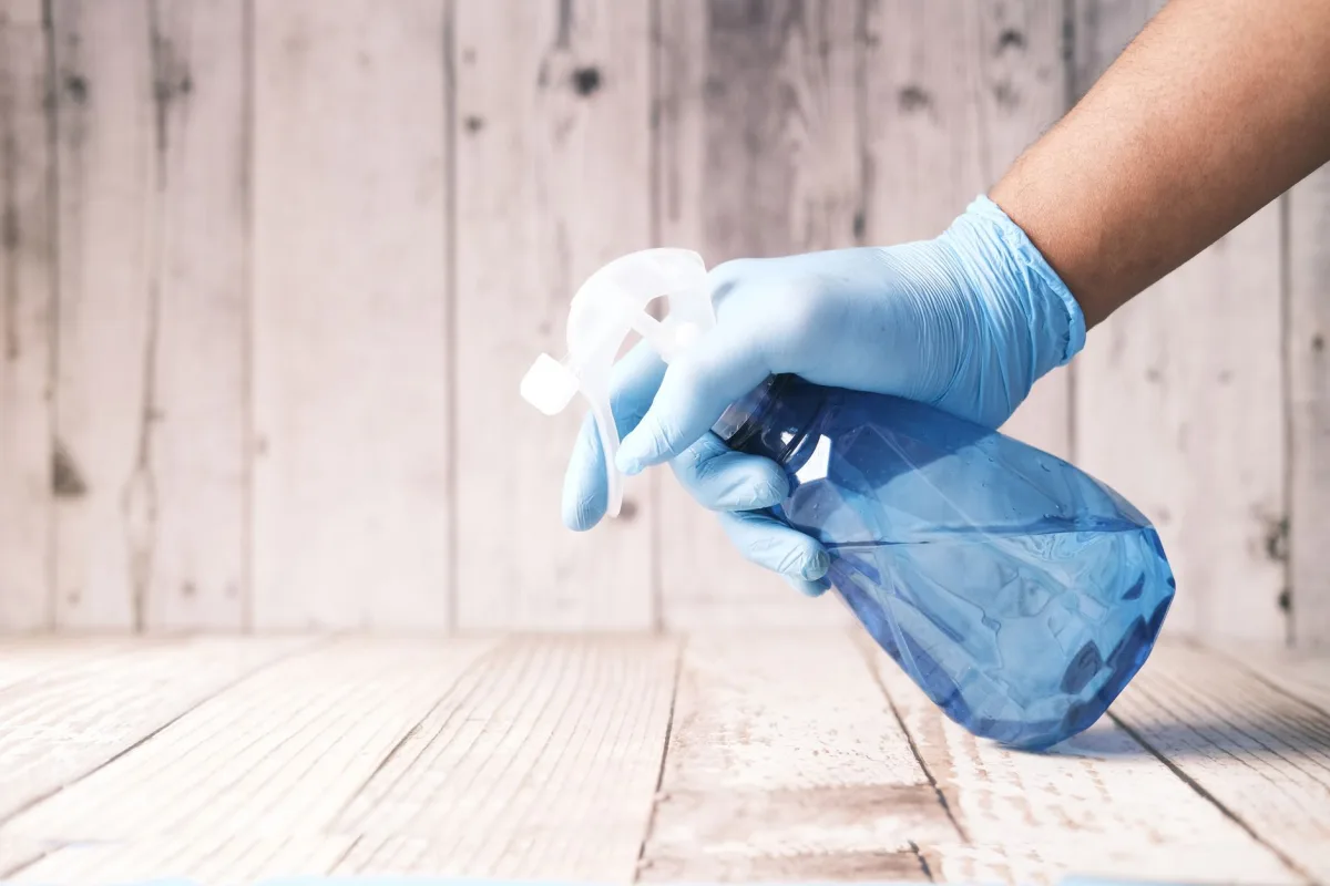 Measuring a capful of liquid laundry detergent above a washing machine