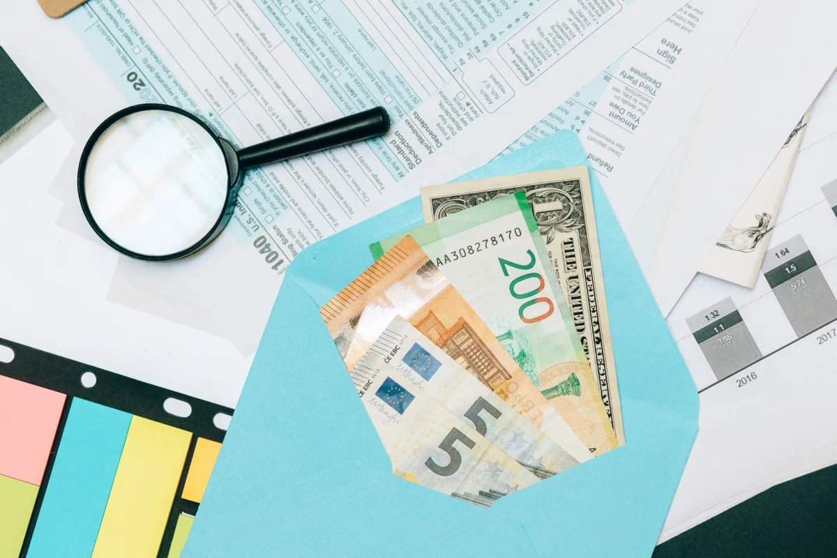 Stack of home service invoices and a calculator on a kitchen table