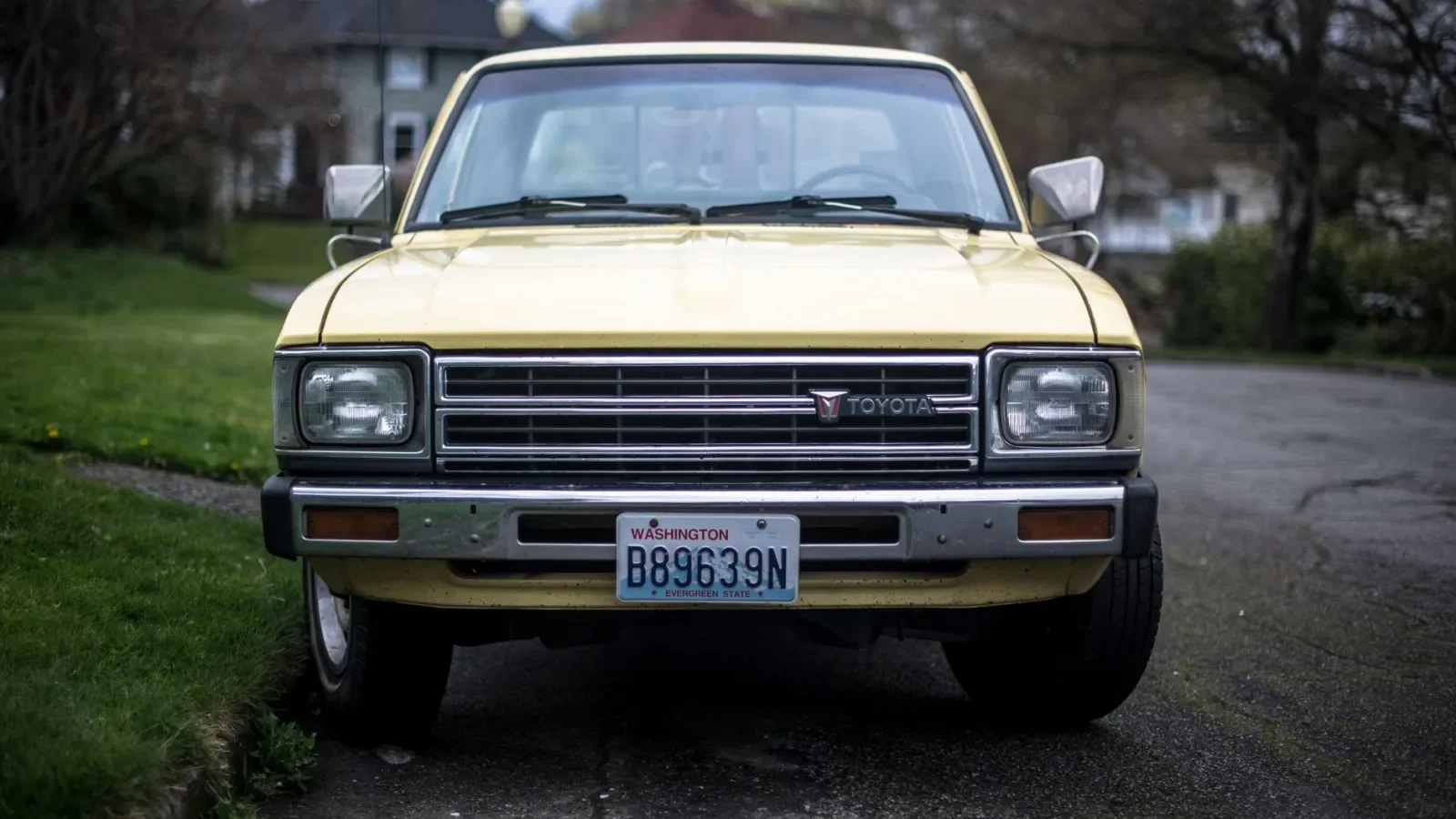 A pickup truck parked on a grassy backyard lawn over a septic drain field