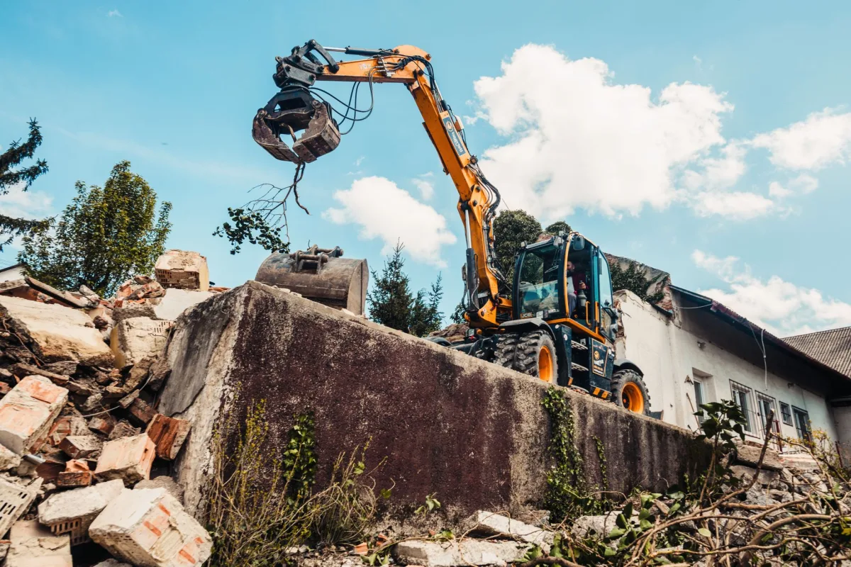 Excavator digging in a backyard for a full septic system replacement