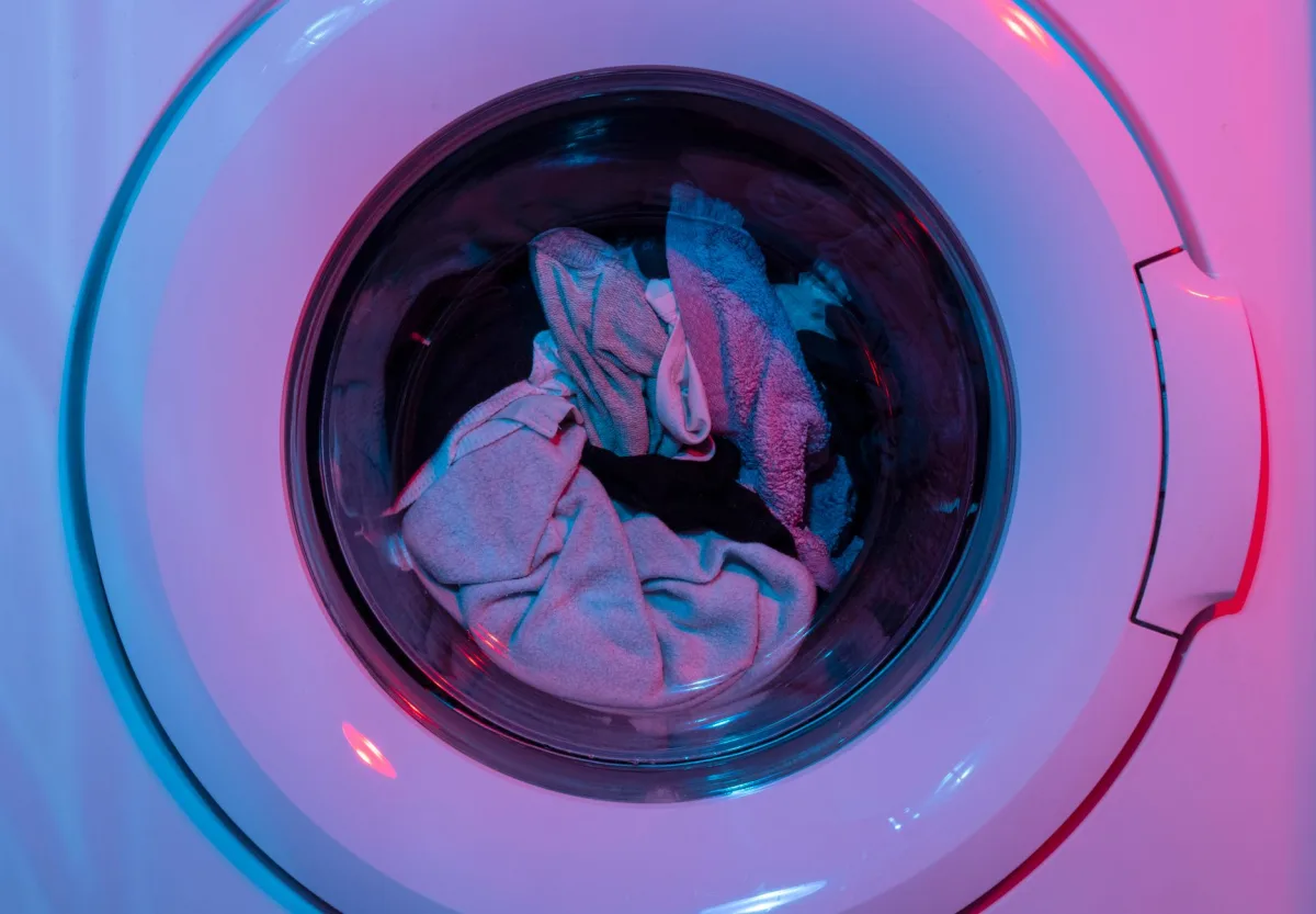 Front-loading washing machine mid-cycle in a home laundry room