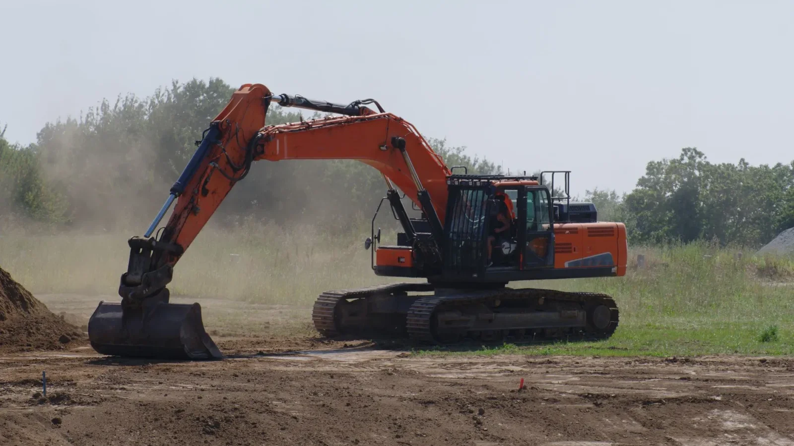 Excavator digging trenches to replace a failing septic drain field