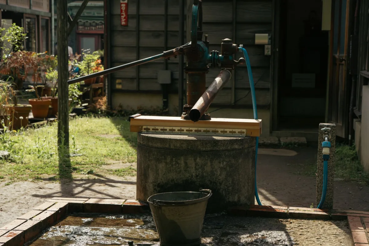 Septic pump truck hose pumping out a septic tank in a yard