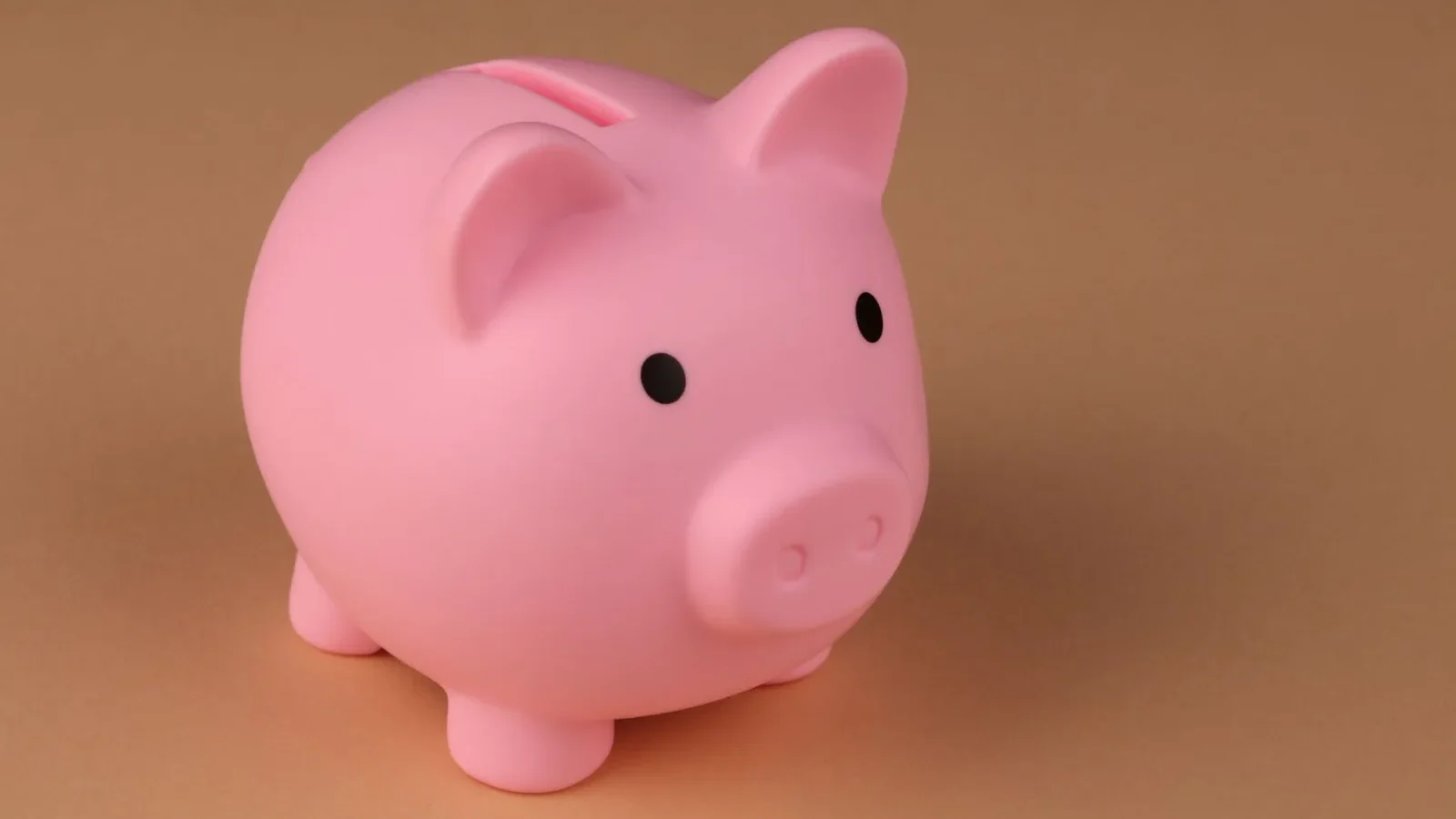 Piggy bank beside coins representing saving money on septic system care