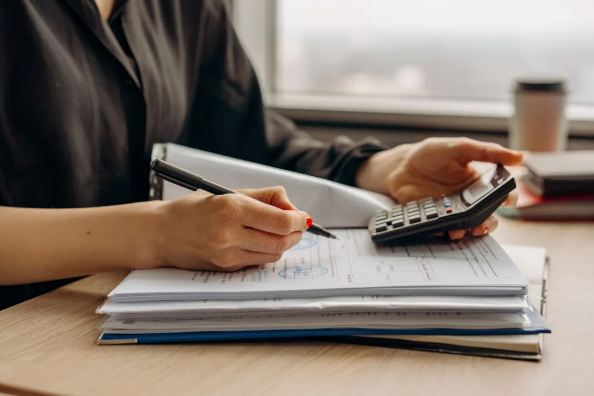 Homeowner using a calculator to estimate septic repair and pumping costs