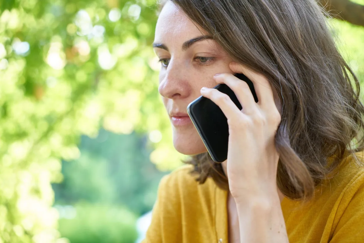 Homeowner making a phone call while holding a repair estimate