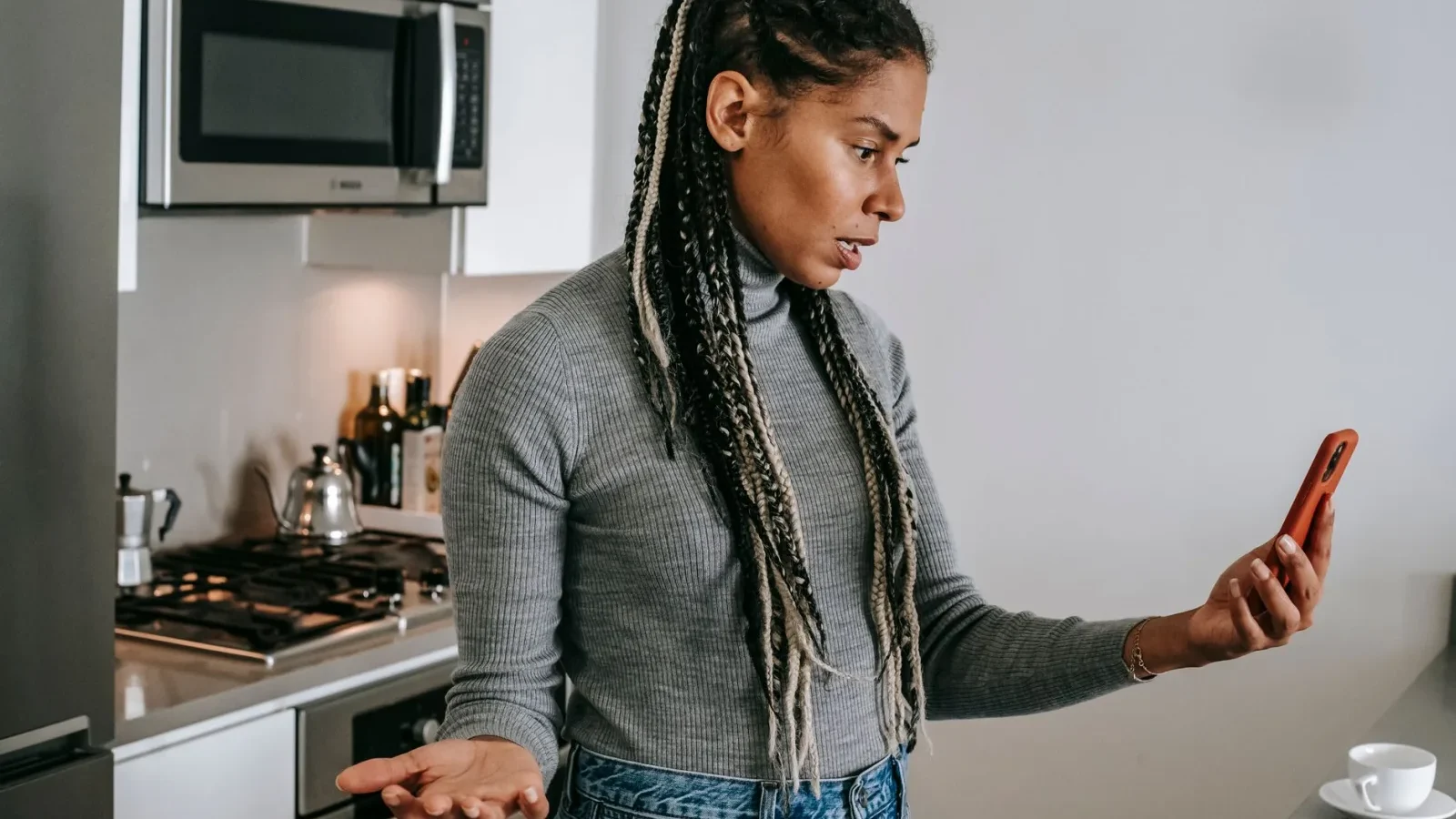 Homeowner checking a phone next to a bathroom sink drain