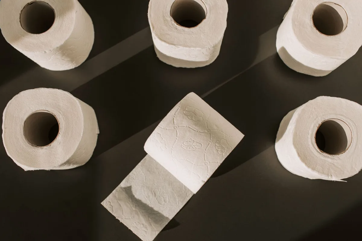 Rolls of thin white toilet paper on a store shelf