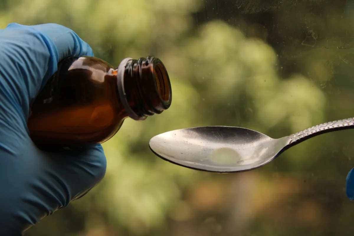 Bottle of liquid septic tank additive being poured into a toilet