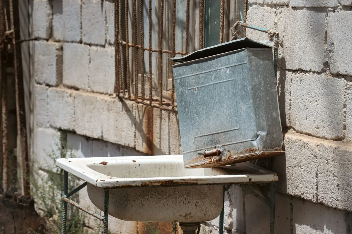 Technician lifting the concrete lid on an open septic tank access point