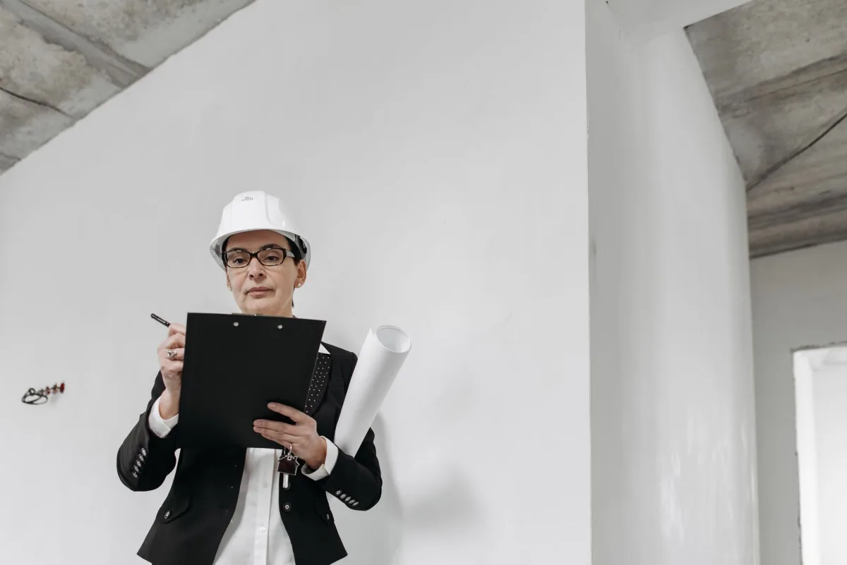 Septic contractor holding a clipboard with a written estimate outside a home