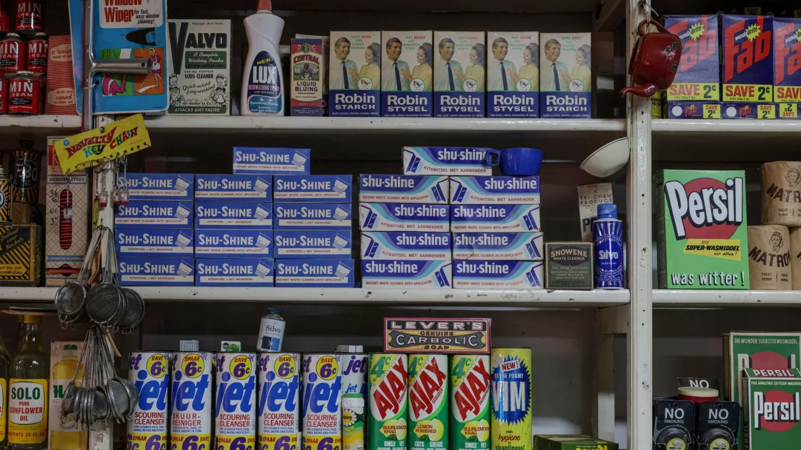 Household cleaning and laundry products lined up on a store shelf