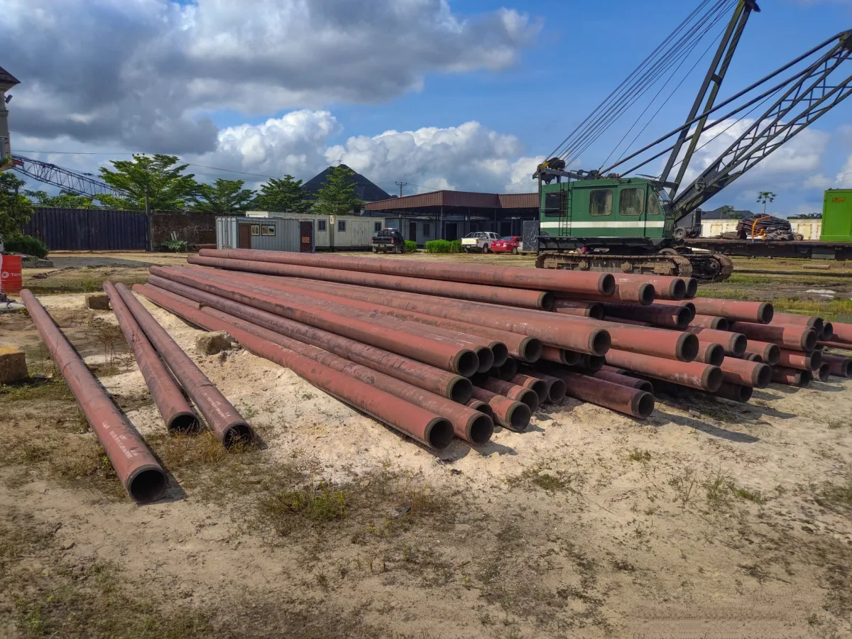 Perforated drain field pipes in gravel trenches being installed in a yard