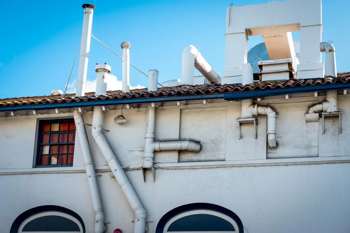Plumbing vent pipe rising through a house roof