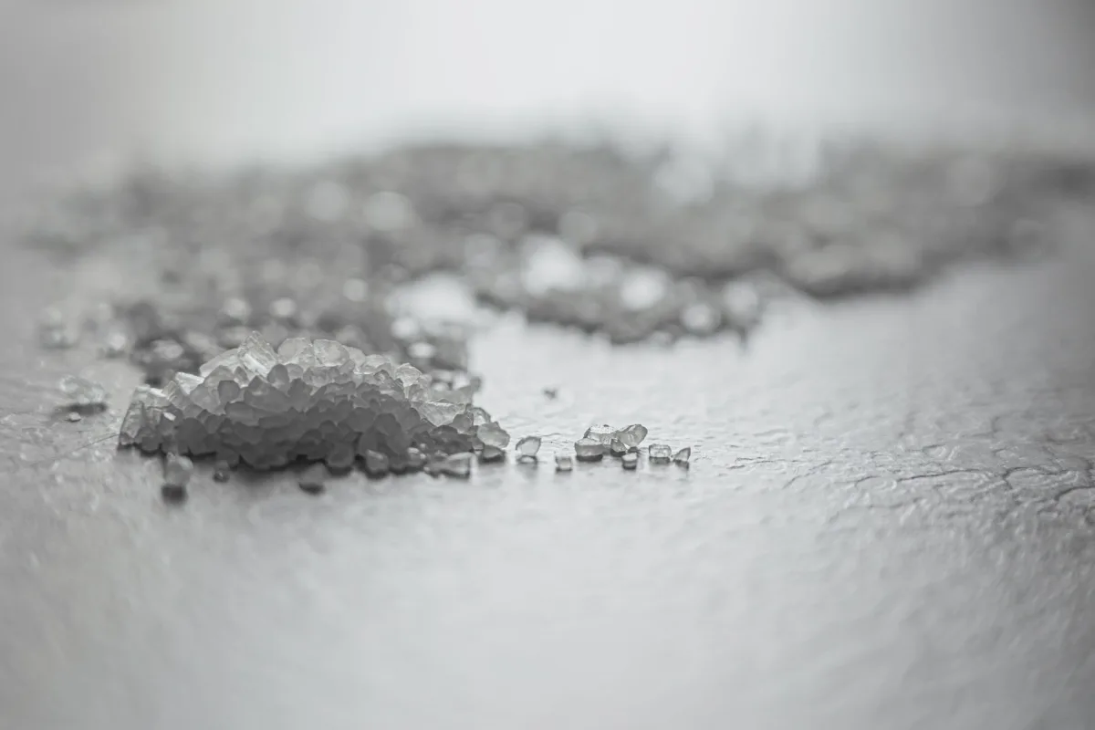Hand pouring salt pellets into the brine tank of a water softener