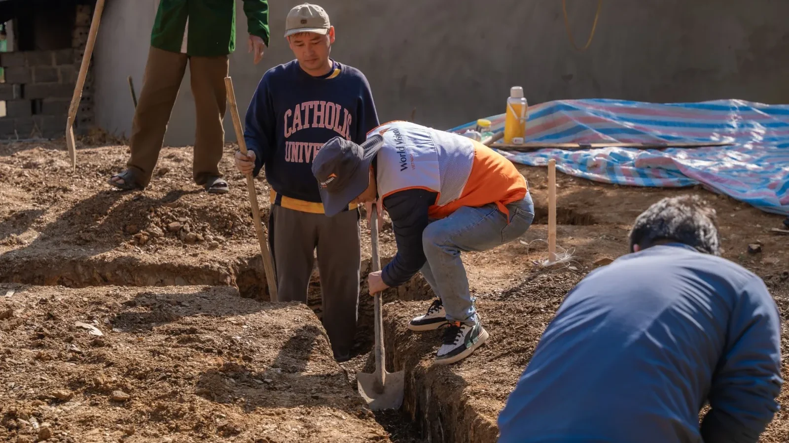 Open septic drain field trench showing gravel soil and perforated pipe